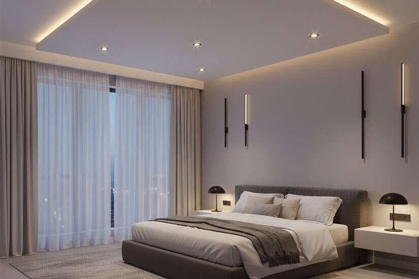 False ceiling design in modern apartment interiors enhances both aesthetics and functionality by adding depth, improving lighting, and creating visual zoning. Using materials like gypsum and POP, designers create layered ceiling structures with integrated lighting such as cove lights and recessed fixtures. This approach not only improves illumination but also elevates the overall ambiance of the space. Ideal for urban homes, false ceilings help conceal wiring, optimize lighting design, and add a modern, sophisticated touch to interiors.